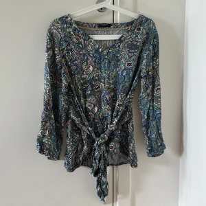 Tröja - Tröja med mönster i främst grönt, blått och vitt! Ett inbyggt bälte vid midjan för att få en mer sinched in effekt och timglasfigur. Storlek xs, passar dock även S