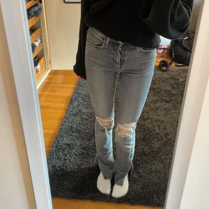 Grå Jeans från Zara - Superfina grå jeans med hål på knäna och slits. Medelhög midja. Väldigt bra skick! Från Zara.