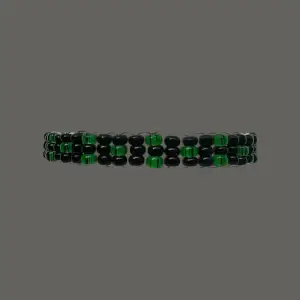 Demeter II är ett snyggt armband uppbyggt av gröna och svarta rocaillespärlor. Armbandet har en omkrets på cirka 18 cm men är töjbart.