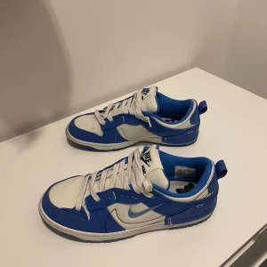 Nike Dunk Low Disrupt 2 'White University Blue Blå - Ett par fina skor i storlek 43 som är som nya, använda 4-5 ggr. Inköpta i Dubai, saknar kvitto och box. Är detta viktigt för dig så får du leta vidare. Kan skicka fler bilder om så önskas! Hämtas i Nacka Strand eller fraktas mot tillkommande kostnad.