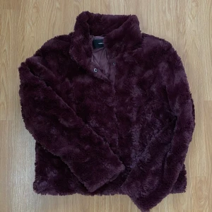 Pälsjacka  - Pälsjacka från Vero Moda i Stl xs, använd 1 gång bara men färgen klär inte mig, därav säljer jag den vidare! Den är vinröd/lila i färgen, olika i olika ljus. Djur och rökfritt hem✨