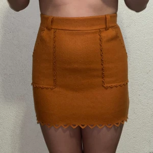 Kjol - Denna vackra orangebruna kjol är helt ny och aldrig använd. Perfekt för att lysa upp din garderob! Storlek XS (för referens väger jag 50 kg).