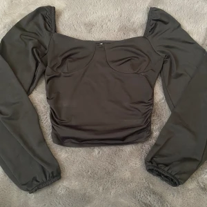 Topp  - Svart topp från NELLY. Slide 3 & 4 visar hur den sitter på. 