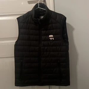Karl Lagerfeld väst  - Hej säljer min Karl Lagerfeld väst i storleken xs passar från 165 till 173 skulle jag säga skick 9/10 förutom ett litet hål i fickan som inte syns när man har på sig västen   nypris 2000 mitt pris 1000 kom gärna med bud 