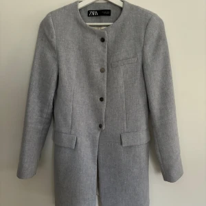 Kappa från zara  - Mycket lite använd, ljusgrå melerad, figursydd med nätta axelkuddar och snygg urringning i hals. Köpt på Zara för 999;- 