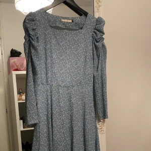 Ljusblå blommig maxiklänning  - Sommarklänning i satin , använd ett fåtal gånger annars i perfekt skick. Köpt utomlands därmed osäker storlek men passar mig som är XS/S. Lutar mer åt S. Perfekt till sommaren , luftig. 