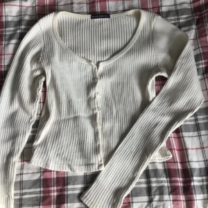 Brandy Melville Cardigan - Cremevit ribbad cardigan från Brandy Melville, cardigan är nopprig och har syn på användning.