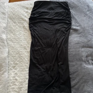 Svart lång kjol low waist/high waist - Helt ny långkjol! I midjan sitter ett band med extra stretch så kjolen anpassar sig beroende på om man vill ha den high eller low waist. Hela kjolen är i ett något stretchigare material vilket gör den enklare att gå i. Jag upplever inte tyger som genomski