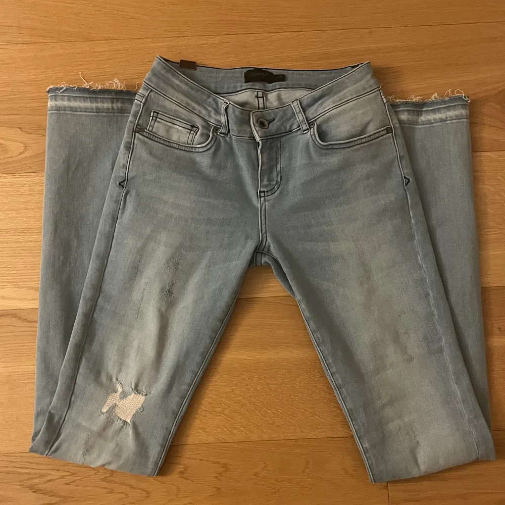 Såå fina lågmidjade jeans med detaljer/slitningar samt slits. Innerbenslängd: 85cm med midjestorlek 26 (≈32cm rätt över). Oanvända!🩵🔥. Jeans & Byxor.