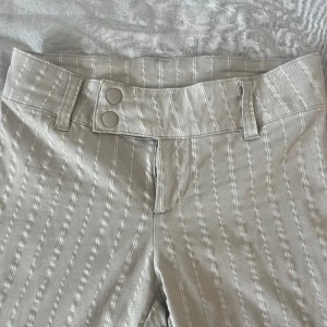 Lågmidjade kostymbyxor  - Beiga, vitrandiga, lågmidjade kostymbyxor. Kommer från H&M och är använda runt fem gånger😊😊. Skriv för fler bilder🙃🫶. 