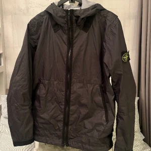 Stone island Vindjacka - Hej! Jag säljer nu min stone island vindjacka som är i toppskick. Dock så finns det en väldigt liten reva längre ner till vänster på ryggen. Ord pris på jackan är 7000:-