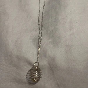 Halsband med bur till kristall  - Halsband i rostfritt stål, med bur. Förvara en kristall eller något annat fint i buren.   Följ _uniquebodies_ på instagram och få 10kr rabatt på ditt köp!