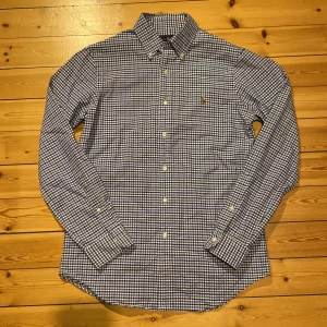 Ralph Lauren skjorta rutig - En mycket fin rutig skjorta från Ralph Lauren. Färgerna är vit, blå och mörkblå. Storlek S men passar bra till M