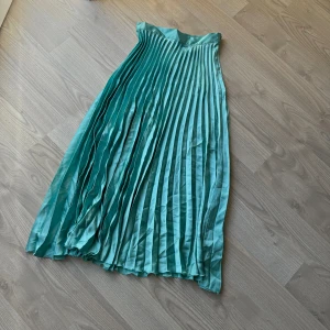 Blå kjol - Blå kjol i ett lite mer glansigt material från Zara. Aldrig använd med prislapp kvar. Storlek 36.