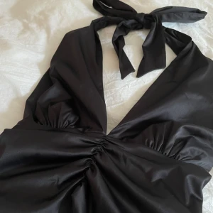 svart topp med öppen rygg  - säljer min fina svarta topp då den inte längre används, använd fåtal gånger så i så gott som nyskick🥰säljs i S men skulle säga funkar både för storlek uppåt och neråt då man knyter den bakom nacken. 