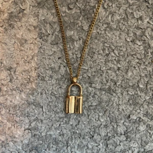 Guld låshalsband  - Häftigt guldfärgat halsband med ett lås som lätt kan användas till din dagliga outfit. Kedjan är 48 cm