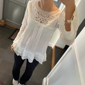 Vit volangblus  - Vit blus från Flamenco med spets och volanger. Storlek S, passar även M. Fint skick. Använd gärna köp nu!