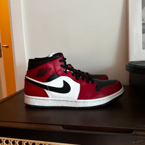 Nike Air Jordan 1 Mid Röd/Vit Strl 42 - Nike Air Jordan 1 Mid i färgerna röd och vit. Skorna är i gott skick och har använts ett fåtal gånger. 