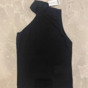 Polo asymmetrisk topp från Gina tricot  -  Helt ny svart asymmetrisk topp från Gina Tricot ribbad i storlek M