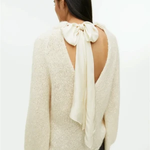 Stickad tröja  - Super söt stickad tröja från arket med en rosett i ryggen, aödrog använd prislappen kvar! Hör av dig för fler bilder. Köpt för 1300 kr