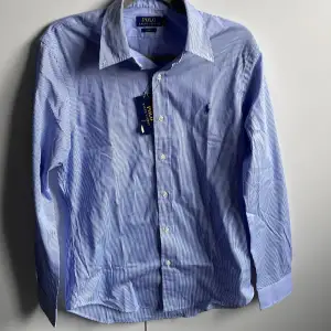 Randig Ralph Lauren skjorta i storlek medium. Den är oanvänd med prislappen kvar. Nypris: 1795 på Ralph Laurens hemsida. 