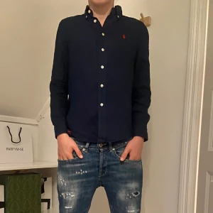 RL skjorta - Ralph laurent linne skjorta i bra skick bara andvänds under en sommar vid få tillfällen. Köpt på NK ej kvitto storlek 10-12år och är stor i storleken han på bilden är 168cm så avgör själva