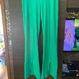 Gröna byxor - Det är ett par gröna ribbade raka mjuka byxor med snitt längst ner på benen.