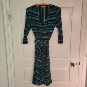 Grön randig klänning - Midiklänning i storlek xs, men den passar s och m. Tyget är cäldigt stretschigt. Jag är 173 och den går ovanför mina knän