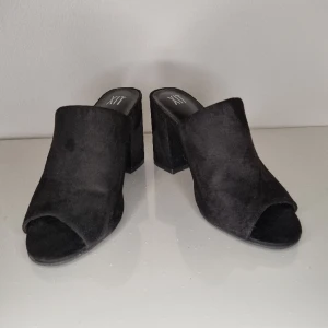 Svarta slip-ins klackskor  - Svarta slip-ins med mockaliknande material. St 36. Klackhöjd 8 cm Endast använda 2 gånger.