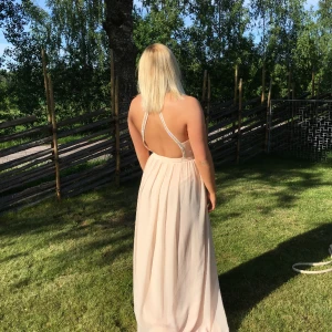 Balklänning  - Säljer min gamla balklänning som är i jättefint skick då den bara använts en gång! Den är ljusrosa i färgen och har glitter baktill som på bilden. 