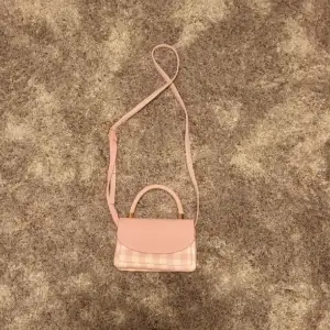 Super fin rosa handväska/axelbandsväska, passar perfekt till sommaren. Den har inga defekter uton några få små hål på framsidan men det är något som har varit dör sedan den köptes, man tänkter knappt på dem!!⭐️