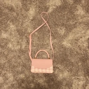 Rosa väska - Super fin rosa handväska/axelbandsväska, passar perfekt till sommaren. Den har inga defekter uton några få små hål på framsidan men det är något som har varit dör sedan den köptes, man tänkter knappt på dem!!⭐️