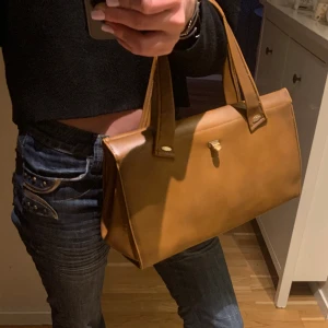 Brun läder väska - Söt läderväska som tyvärr inte kommer till andvänding. Köpt secondhand för 500 men den har fått lite fläckar och små hål på innsidan därav det lite billigare priset. Dock är väskan hyfsat bra skick på utsidan. ⭐️ Bredd: 35cm Djup: 13cm Höjd: 22