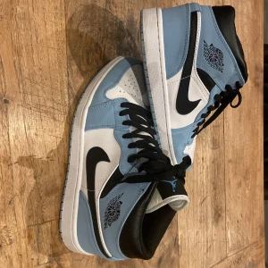 Air Jordan 1 university blue - Hej! Dags att sälja mina skor då jag tyvärr växte ur dem för snabbt. Använda fåtal gånger. Lite slitningar på insidan men inget som stör, se bild.  Annars i mycket fint skick!  Härlig ljusblå färg!  Innermått 27cm, mätt med mätsticka. 