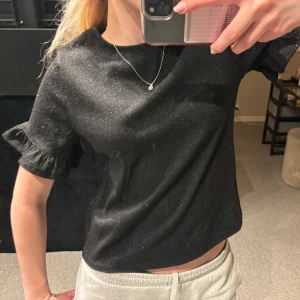 Glittrig topp  - Säljer en super fin glittrig topp med volanger i armarna. Helt oanvänd. Skriv för fler frågor eller bilder. (Köpare står för frakt)💗