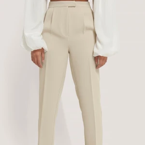 Beiga kostymbyxor  - Kostymbyxor från Na-kd, använda kanske 6-7 gånger så nästan som i nyskick. Tycker om dom jättemycket och tycker de sitter bra men tyvärr för små för mig.