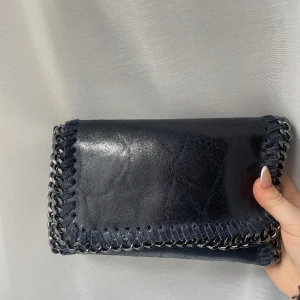 Väska  - Likadan väska som den gråa, i fint sick och har band till. Är i Italienskt läder och använd fåtal gånger. (Den är marinblå om de inte framgår)