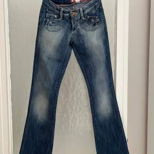 Bootcut jeans med låg midja. Små i storleken. Knappgylf. 