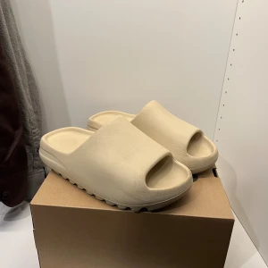 Yeezy slide bone - Tja! Söker nu dessa Yeezy slidesen i färgen Bone! De är i gott skicka och helt perfekt nu tills sommaren! Otroligt sköna!  Storlek 43 men passar mig som har 42 också!  Priset kan förhandlas vid smidig affär!