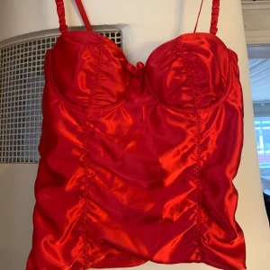 Röd korsett - Röd korsett i siden. Oanvänd.