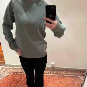Grå hoodie  - Säljer denna super sköna grå/gröna hoodie. Den är så skön och varm, helt perfekt att ha hemma! Den har en blekt fläck på mitten av tröjan men utöver det är den som ny