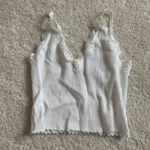 crop top linne - vit, ribbad, crop top linne med spets från pull&bear. strl xs men banden går att justera.