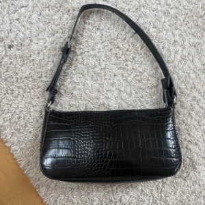 Svart axelväska - En svart axelväska med perfekt storlek där du får plats me mobil, nycklart ,kort osv. 