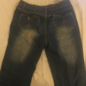 Jeans med hjärt fickor  - Jeans med hjärt fickor i bra skick lite slitna längst ner vid benen men annars bra skick! 