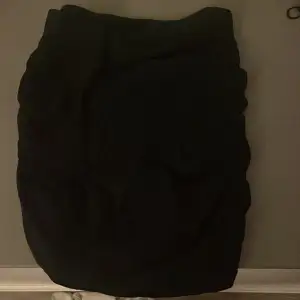 En svart kjol med en söm på baksidan som är använd några gånger men är i bra skick