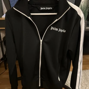 Palm Angels Tracksuit Hoodie  - Hej! Säljer nu min Palm Angels Tracksuit Hoodie då den inte kommer till användning. Använd ett fåtal gånger därav nyskick.  • Storlek S Digitalt kvitto finns.  !!Priset ej hugget i sten!!