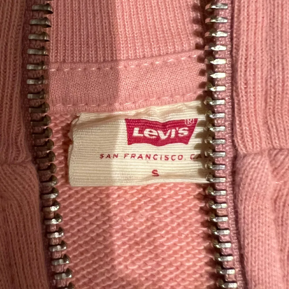 Rosa half zip tröja från levi's. Aldrig använt så den är i nyskick. OBS! Ljuset hemma är gult så tröjan kan se lite orange ut på bild fastän den är rosa. 100% Bomull. Skriv gärna vid funderingar🌷. Tröjor & Koftor.