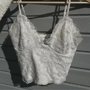 Topp med spets - Fin topp med blommiga spetsdetaljer. Perfekt för sommar och fest 🤍