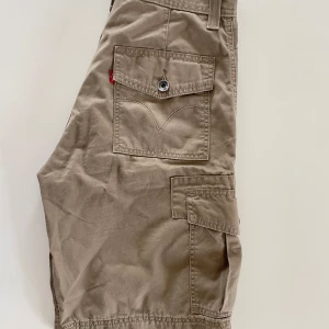 Levis cargo shorts - Långa Levis cargo shorts, med snygga fickor och detaljer! Skriv vid fler frågor❣️priset plus frakt gäller😊skriv gärna innan du använder ”köp nu”!