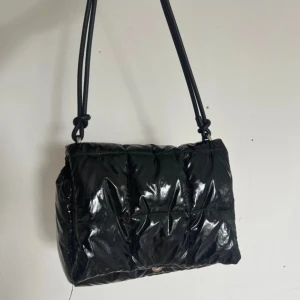 Väska - Säljer en glansig väska från H&M! Mellanstor och bra skick, säljs för 60kr!☺️